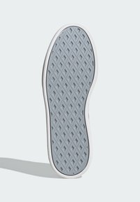 Podošva topánky z gumy svetlosivej farby s textúrovaným povrchom s diamantovými vzormi a bielym lemom.