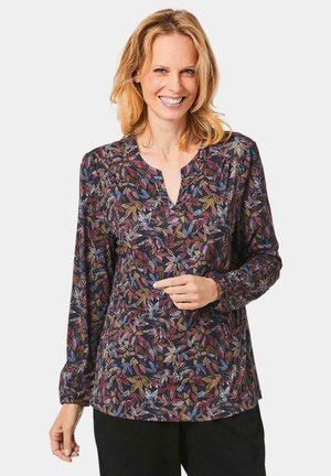 Langärmlige Bluse aus dunklem Stoff mit einem bunten Blattmuster. Sie hat einen V-Ausschnitt und geraffte Manschetten. Bequeme Passform mit einer glatten Textur.