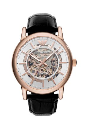 Montre mécanique squelette ton or rose avec bracelet en cuir noir, engrenages apparents et logo Emporio Armani sur le cadran.