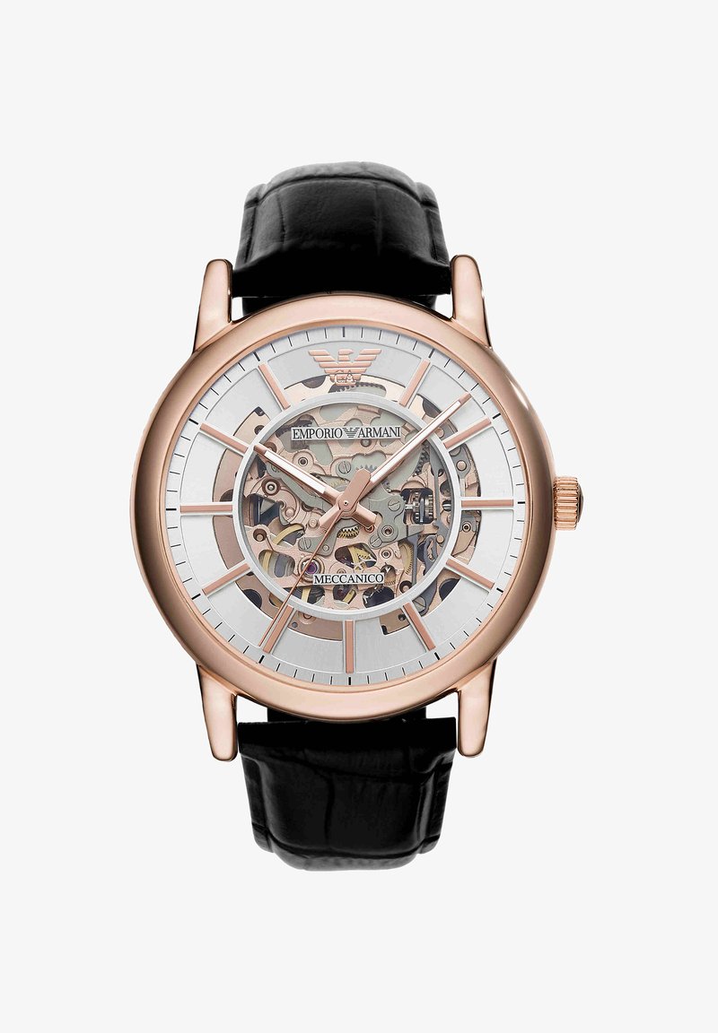 Mechaniczny zegarek szkieletowy w odcieniu różowego złota z czarnym skórzanym paskiem, widoczne tryby i logo Emporio Armani na tarczy.