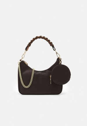 Petit sac à main marron foncé avec une poignée froncée, des détails en chaîne dorée et une pochette à pièces ronde attachée sur fond blanc.