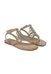 Sandali in suede beige con decorative lacci metallici, suola piatta e cinturino regolabile alla caviglia per una vestibilità sicura. Design open-toe.