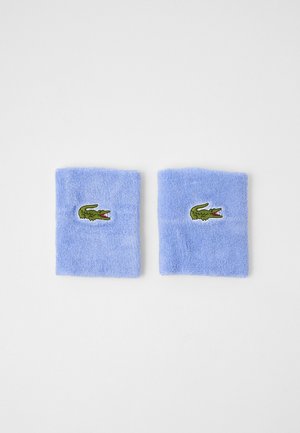 Blue terry cloth wristbands featuring a green crocodile logo with red accents; soft texture, rectangular shape, and stitched detail.