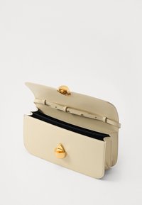 Bolso de mano de cuero beige con un cierre de hardware dorado, que presenta una forma estructurada y compartimentos interiores, forrado en tela negra.