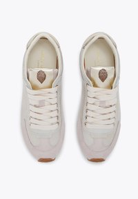 Lichtbeige sneakers van suede en glad leer, met crème veters, een metallic gouden binnenzool en een decoratieve schelplogo.