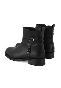 Bottines en cuir noir avec un bout arrondi, détail de boucle sur le côté, petit talon et finition lisse, présentant une couture subtile autour du haut.