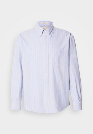 Camisa de botones hecha de una tela ligera, con rayas verticales azules y amarillas, mangas largas y un bolsillo en el pecho a la izquierda.