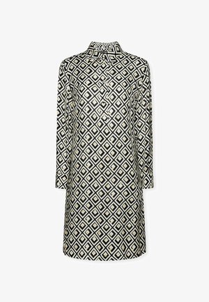 Schwarz-weiße gemusterte Bluse mit geometrischem Diamantdesign, langen Ärmeln und Mandarin-Kragen mit Knopfleiste.