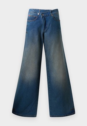 Jean bleus à jambes larges en denim, présentant une finition légèrement délavée, des coutures visibles, deux poches avant et une fermeture à bouton.
