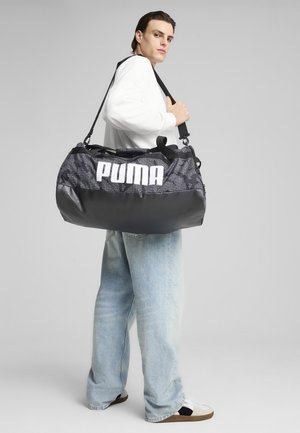 Crna i siva torba za sport s "PUMA" logotipom, s teksturiranom tkaninom i glatkom bazom. Podesivi remen i dvostruke ručke.