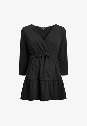 Czarna bluzka z rękawami 3/4, zebranym pasem i wiązaniem w talii. Posiada rozszerzający się dolny materiał z falbaną. Wykonana z miękkiej tkaniny.