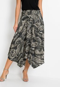 Gonna nera e beige con motivo paisley, dalla silhouette fluida e con elastico in vita. Realizzata in un tessuto leggero.