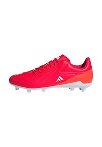 Botín de fútbol rojo con parte superior sintética, acentos blancos, punta afilada y seis clavos desmontables para tracción en superficies de hierba.