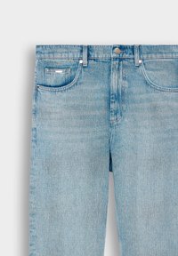 Lyseblå denimjeans med et klassisk fem-lomme-design, glidelås med metallknapp, og subtile falminger over hele stoffet.