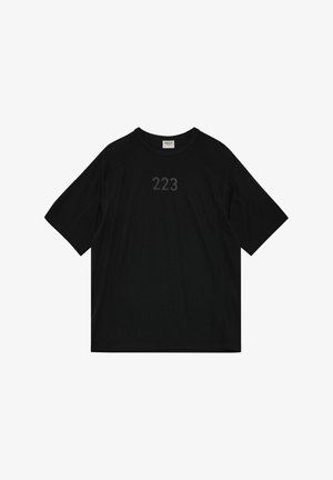Schwarzes, kurzärmeliges Freizeitshirt mit rundem Ausschnitt, dezentem "223"-Aufdruck auf der Brust und einem kleinen Etikett mit der Aufschrift "HALO" an der Innenseite des Kragens.