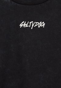 Juodas medvilnės džemperis su apykakle, tekstūruotas audinys ir balti spausdinti žodžiai „SALTYDOG“ priekyje.