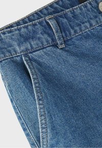 Jean en denim bleu avec une finition texturée, comprenant une ceinture, un bouton en métal et des coutures contrastées le long des coutures.