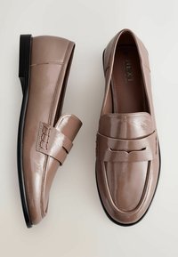 Hellbraune Lackleder-Slipper mit einem dekorativen Riemen und gestickten Details. Sie zeichnen sich durch eine glatte Oberfläche und eine niedrige, schwarze Sohle aus.