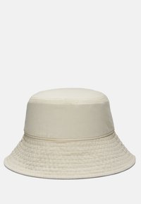 Cremefarvet bucket hat lavet af blødt stof, med en bred, struktureret skygge og en glat, udekoreret overflade.