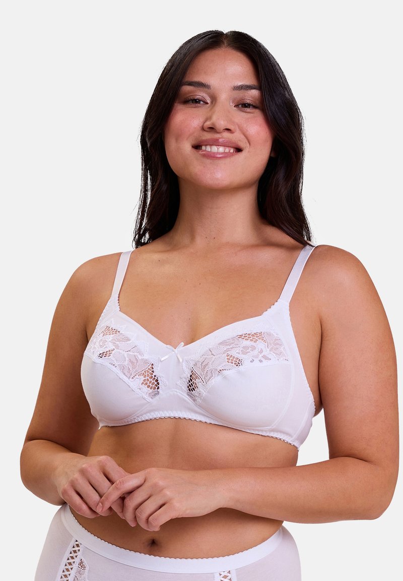 Soutien-gorge blanc avec des détails en dentelle sur les bonnets et un petit nœud au centre. Les bretelles sont fines et le tissu semble lisse et extensible.