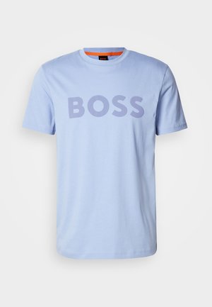Tricou din bumbac de culoare albastru deschis, cu guler rotund și mâneci scurte, având cuvântul "BOSS" afișat proeminent în litere îngroșate de culoare mov închis.