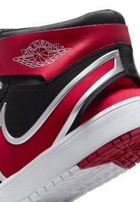 Roter, schwarzer und weißer Air Jordan-Sneakerabsatz mit silbernem Nike-Swoosh und Air Jordan-Wings-Logo auf einem weißen Hintergrund.