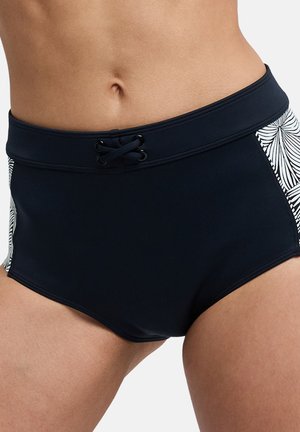 Zwarte zwemshorts met witte, patroon zijpanelen en een vetersluiting aan de voorkant gedragen op de taille, waarbij de omvang en bovenbenen zichtbaar zijn.