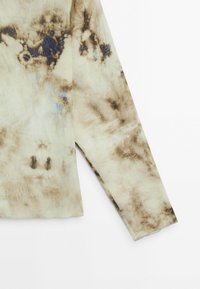 Haut à manches longues en tissu léger, présentant un motif tie-dye avec des nuances de beige, marron et bleu. Coupe décontractée avec un ourlet droit.