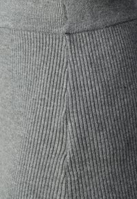 Tejido de ribete gris con textura vertical, que presenta un diseño sin costuras y un material suave y elástico para mayor comodidad.