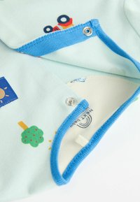 Completo per neonati in cotone azzurro chiaro, caratterizzato da vivaci motivi di un sole, un albero e un'anatra, con bottoni blu e una morbida fodera crema.