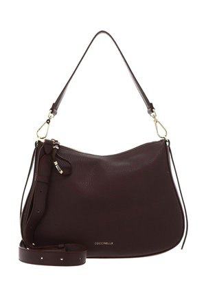 Sac à bandoulière en cuir marron foncé avec fermoirs dorés, sangle réglable, fermeture éclair, et petit logo Coccinelle au centre avant.