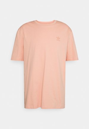 T-shirt rosa chiaro a maniche corte realizzato in cotone, dotato di un piccolo logo Adidas tono su tono sul petto, collo rotondo e una vestibilità morbida.