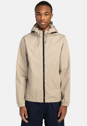 Beige lichtgewicht jack met een capuchon, zwarte rits, elastische manchetten en koordjes. Gladde textuur zonder zichtbare patronen of logo's.