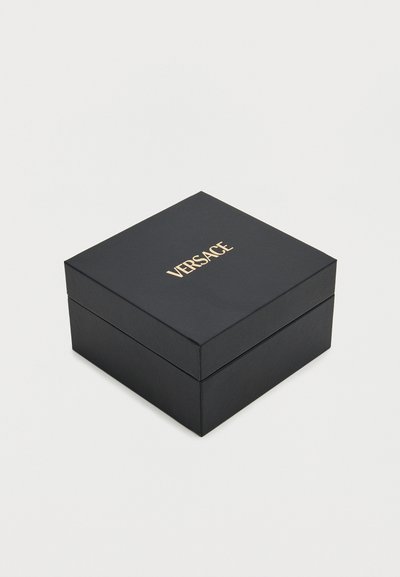 Boîte carrée noire de luxe avec logo VERSACE doré sur le couvercle, sur fond blanc uni.