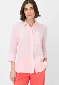 Light pink linen shirt with a collar, button-down front, long sleeves, and a single chest pocket. Soft texture and relaxed fit.