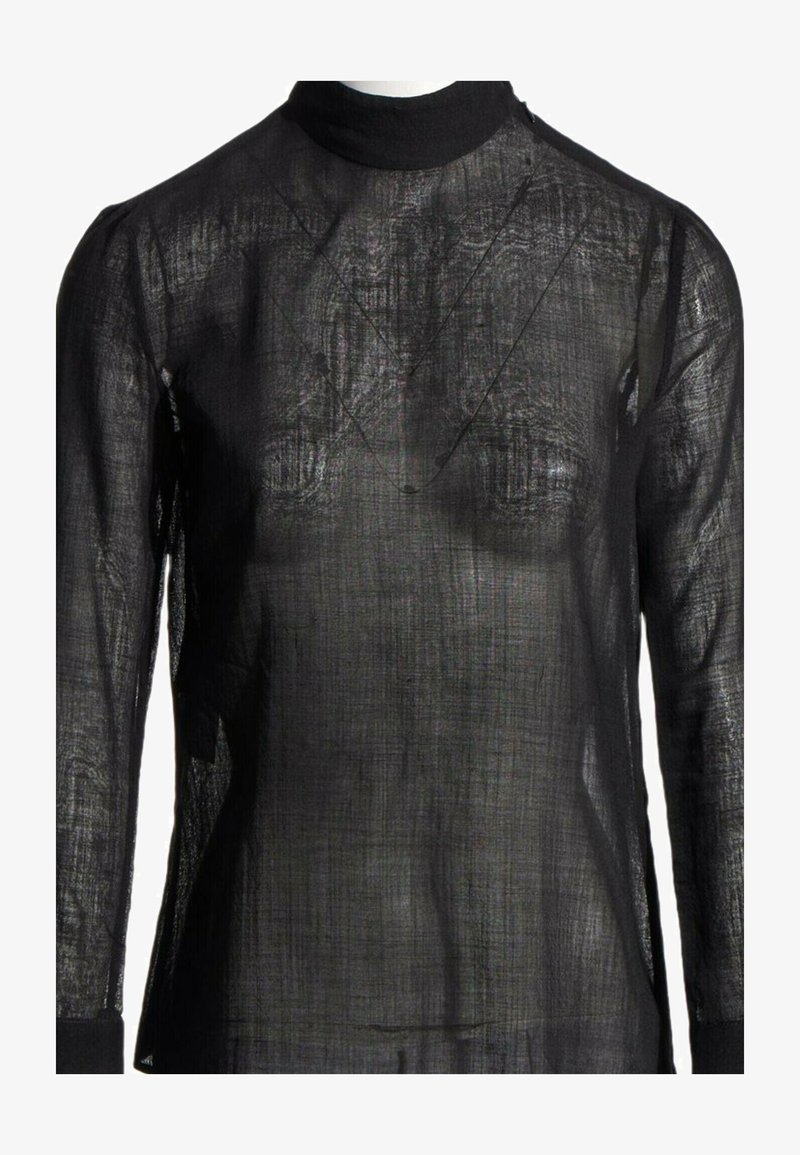 Haut col roulé à manches longues noir transparent avec un tissu texturé et translucide révélant les détails de la construction en couches.