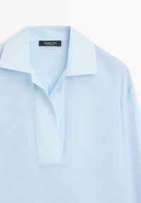 Lichtblauw overhemd met kraag, verborgen knoopsluiting en korte mouwen, gemaakt van gladde stof.