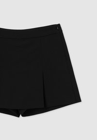 Pantaloni corti neri con un design su misura, caratterizzati da un frontale plissettato, una texture liscia e una chiusura laterale con zip.