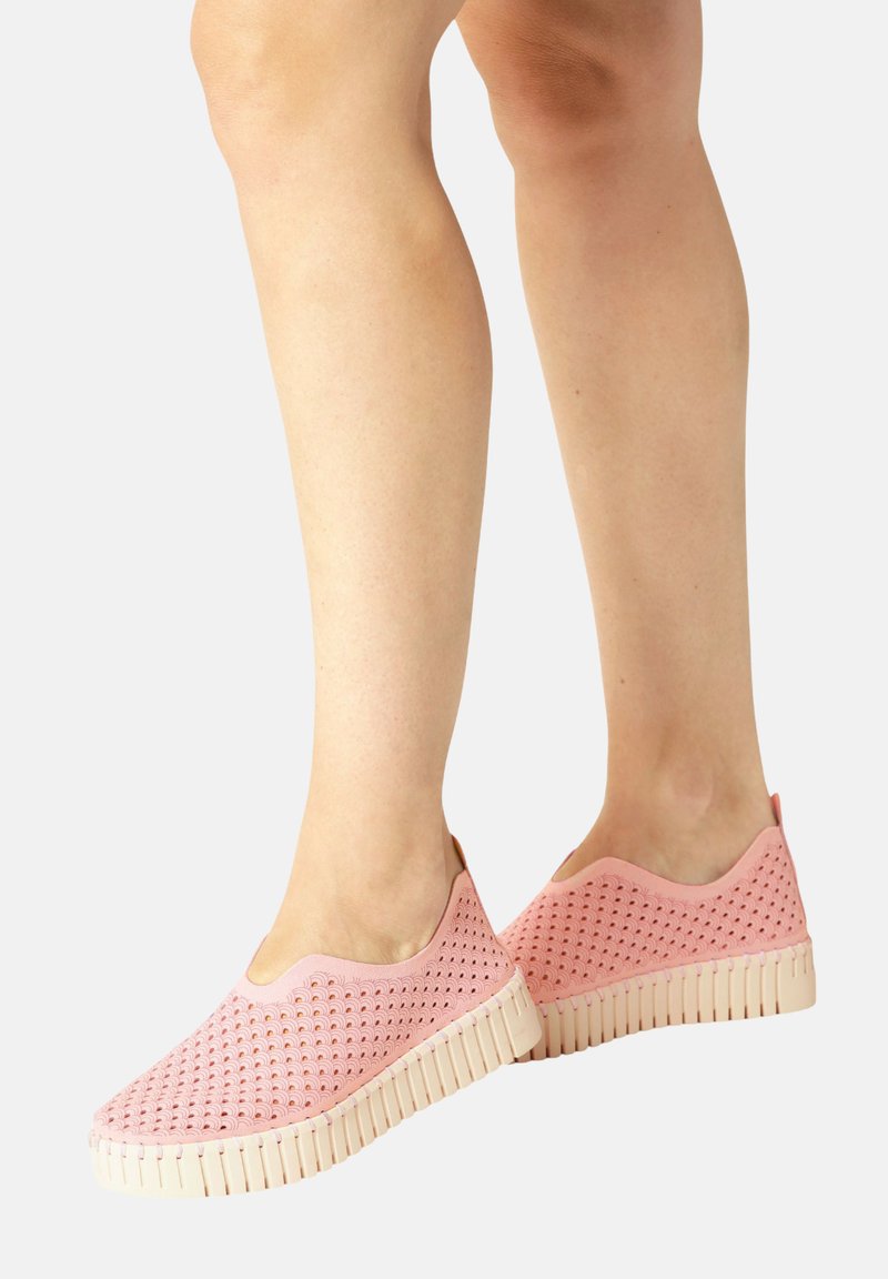 Helle rosa Slipper mit perforiertem Design, kontrastierender weißer Gummisohle, rundem Zehenbereich und dezentem Absatzakzent.