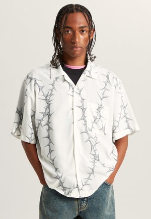 Korte mouwen overhemd met knopen in witte stof met een grijs doornachtig patroon, voorzien van een borstzak en een ontspannen pasvorm.
