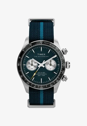 Zegarek Timex Waterbury posiada stalową obudowę, niebieską tarczę, funkcje chronografu oraz pleciony granatowy pasek z akcentami w kolorze turkusowym.