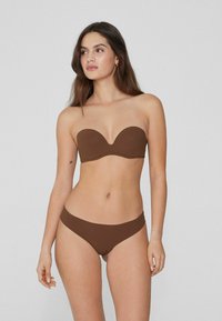 Brauner trägerloser Bikini-Oberteil mit glatter, matter Textur und sanften Kurven. Passender Bikini-Slip mit tiefem Bund, beide im gleichen satten Braunton.