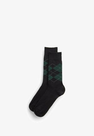 Para czarnych skarpetek do kostki z zielono-białym wzorem w romby w okolicy łydki.