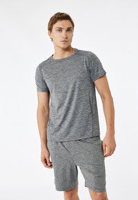 Grau Sport T-Shirt und Shorts-Set, strukturierter Stoff mit meliertem Muster, kurze Ärmel, runder Ausschnitt und lockere Passform.