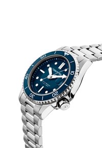 Nerūsējošā tērauda pulkstenis ar tumši zilu ciparnīcu, apzīmētām stundu indikācijām un sudraba krāsas rāmīti. Iespējo saistīts metāla aproce un kronis.