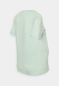 T-shirt de algodão verde menta, de corte solto, mangas curtas, textura suave, decote redondo, com a bainha ligeiramente curvada, sem padrões ou detalhes visíveis.
