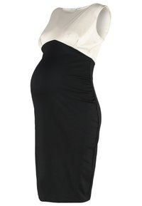 Robe de maternité avec un design bicolore, haut crème et corps noir, sans manches, texture lisse et coupe ajustée.