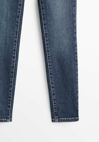 Mörkblå denimjeans med rak bendesign. Har minimal sömnad, en lätt blekning och standarduppvikning vid anklarna.