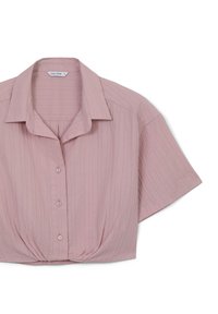 Blusa a maniche corte di colore rosa chiaro realizzata in tessuto strutturato con righe verticali, dotata di colletto e chiusura a bottoni frontale.