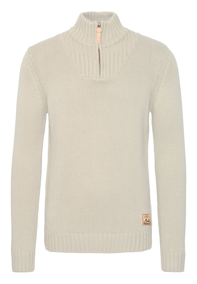Pulover tricotat de culoare crem, cu guler înalt și fermoar pe jumătate. Are manșete și tiv ribbed, un model texturat și o mică etichetă a mărcii la talie.